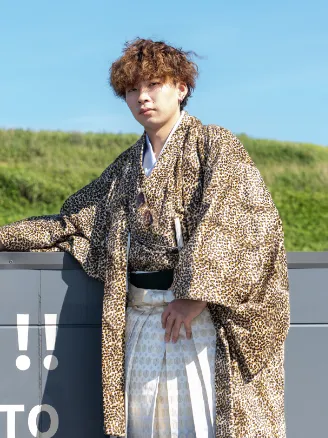 出雲・米子の成人袴のレンタル・紺色の羽織と袴を着て、笑顔でポーズをとる男性。