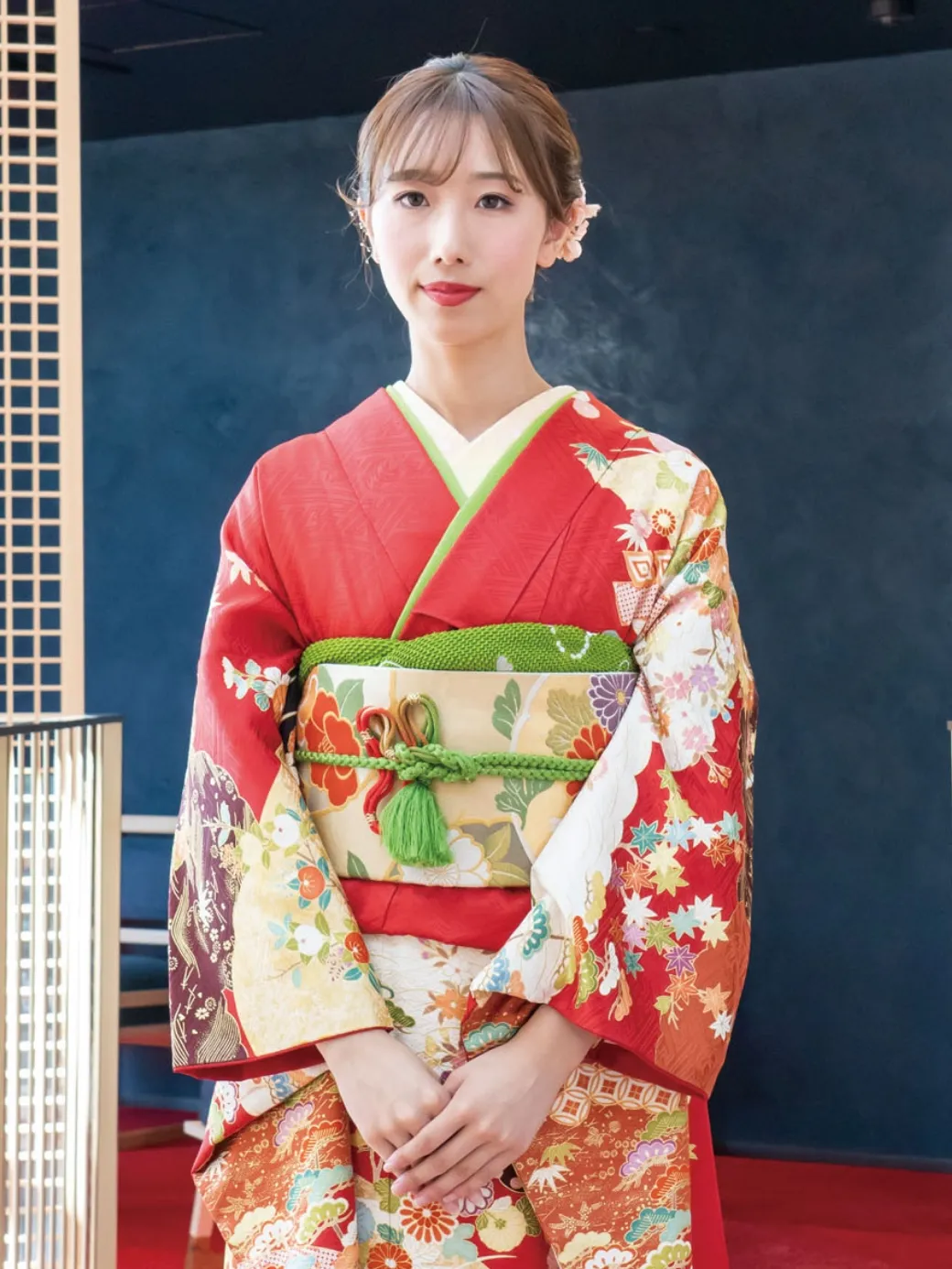 出雲・米子の成人振袖のレンタル・明るい青と緑の振袖を着て、店頭で笑顔でポーズをとる2人の女性。豊富な最新トレンドの振袖ラインナップを象徴。