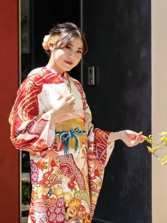 出雲・米子の成人振袖のレンタル・赤とオレンジの華やかな古典柄の振袖を着て、ポーズをとる女性